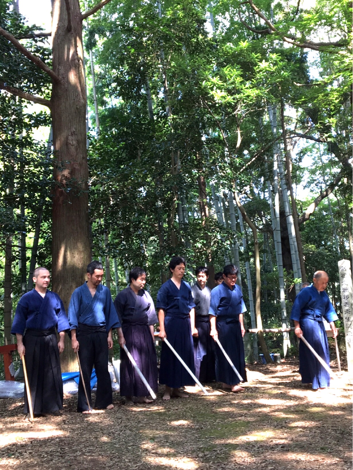 Participants in a sword demonstration standing outdoors with swords
